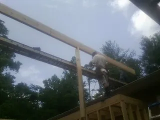 Carpenter setting a ridge beam over a new addition frame — Ice Dam Removal by Roofing Brothers in Brook Park