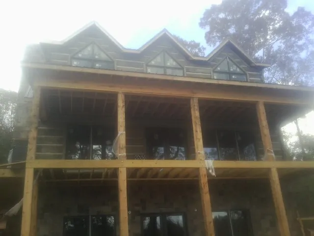Dormers and porch framing on a large log home under construction — Roof Coating work by our crew in Brook Park