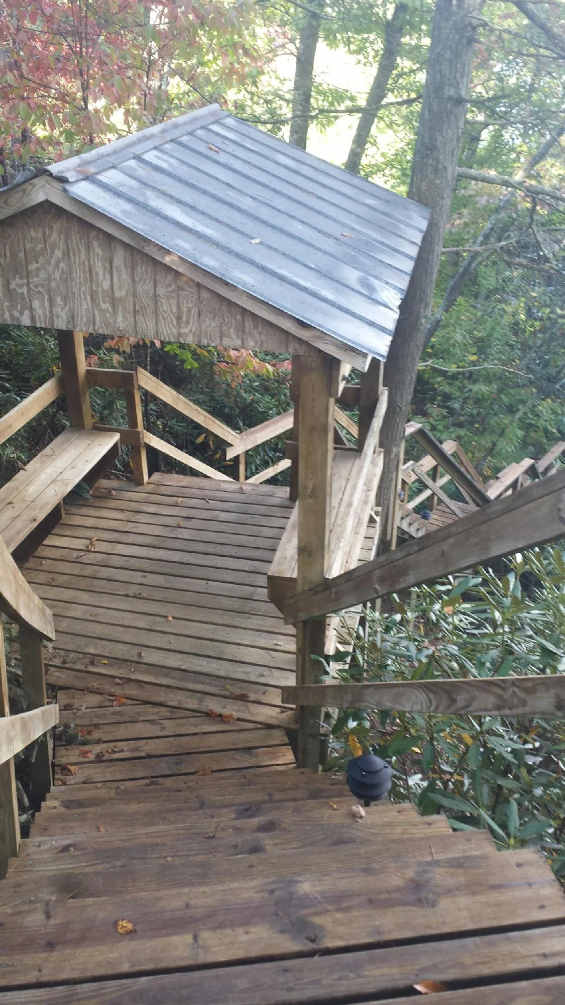 Metal roofed shelter over wooden steps on a wooded walkway — Skylight Repair & Installation work by our crew in Brook Park