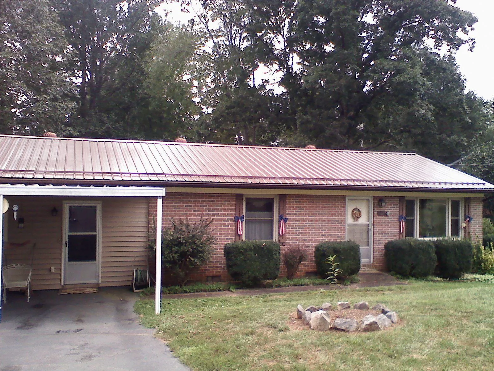 Bronze metal roof and carport on a brick ranch home — Roof Repair work by our crew in Brook Park