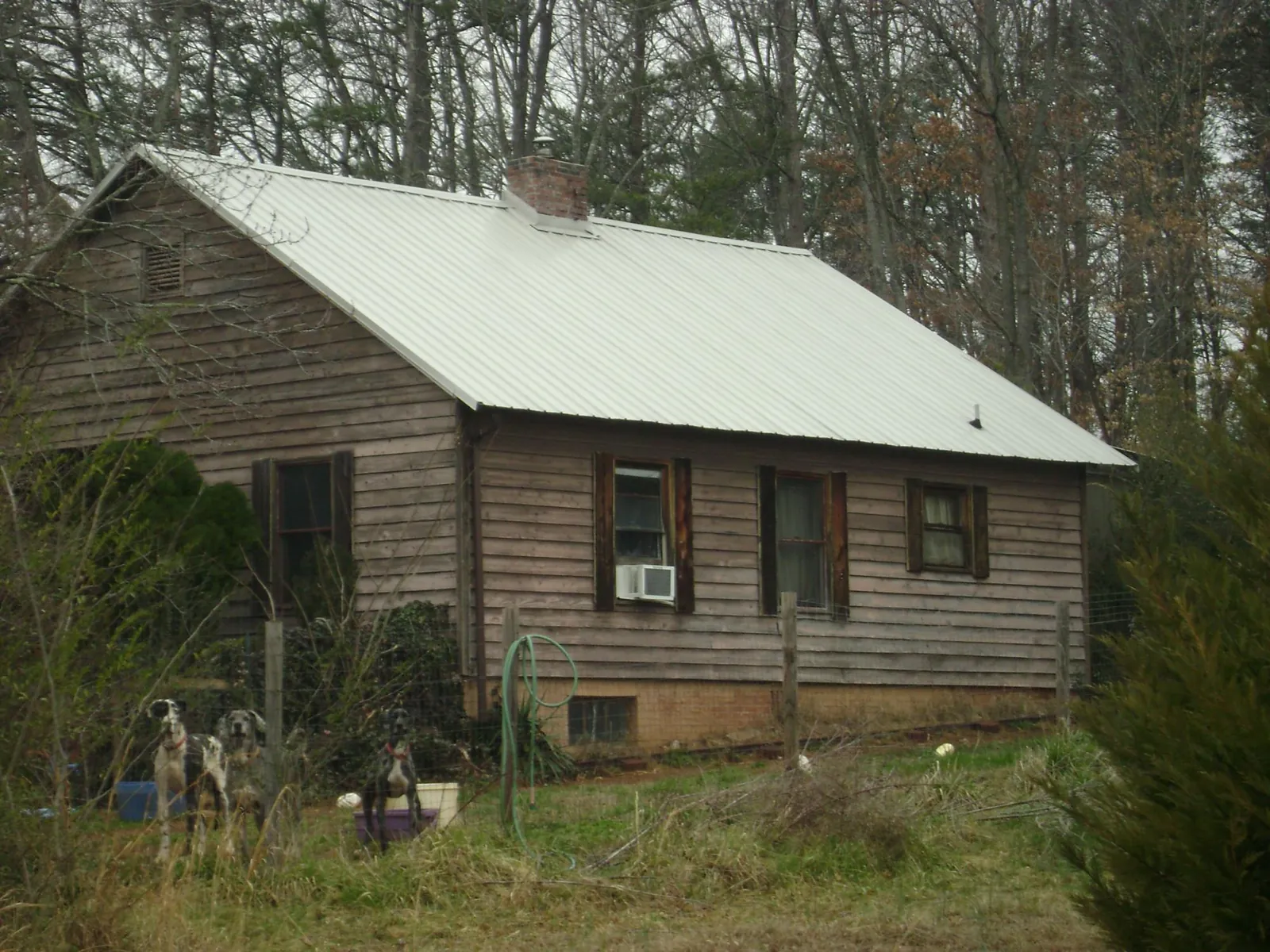 White metal roof on an old wood sided farmhouse, from a Metal Roof Installation job in Brook Park